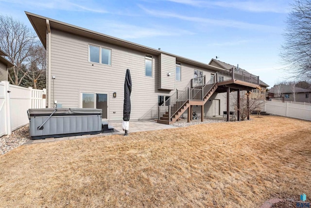 rear view of property with a deck, a patio, a fenced backyard, stairway, and a hot tub