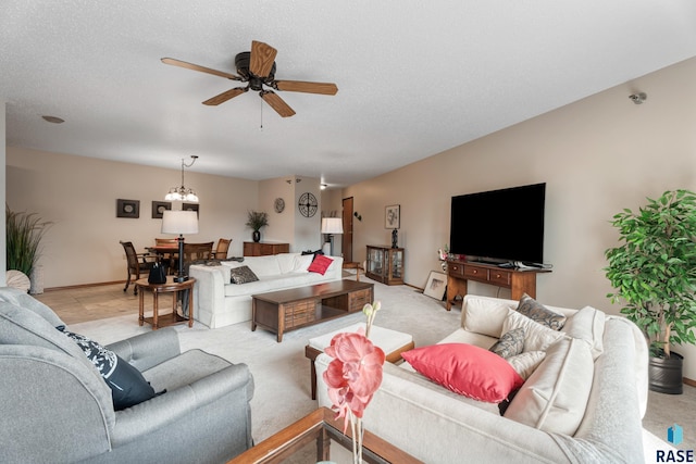 living room with baseboards, a textured ceiling, and ceiling fan with notable chandelier