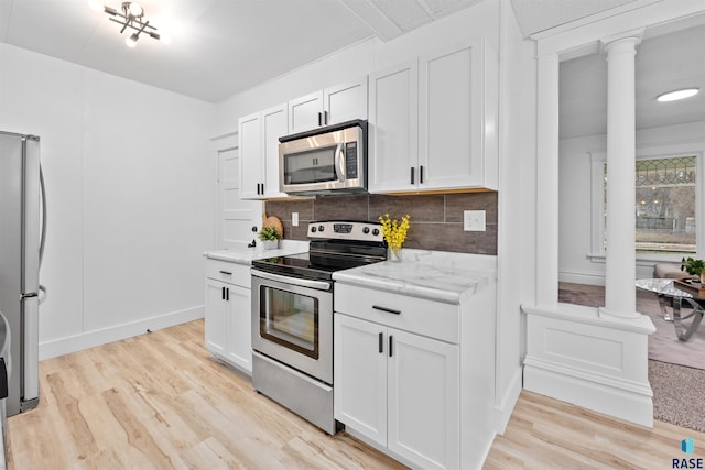 kitchen featuring stainless steel appliances, light wood-style flooring, and ornate columns