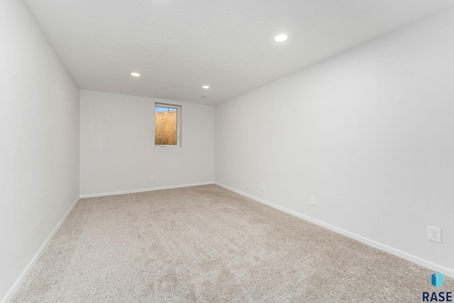 spare room with recessed lighting, baseboards, and carpet