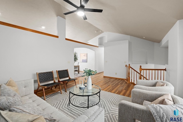 living room with lofted ceiling, ceiling fan, arched walkways, and wood finished floors