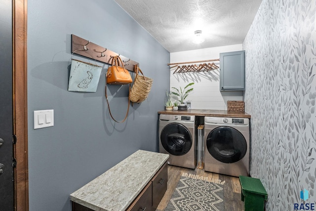 washroom with cabinet space, a textured ceiling, dark wood-type flooring, and washer and dryer