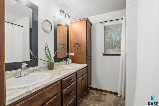 bathroom featuring a sink, visible vents, and baseboards