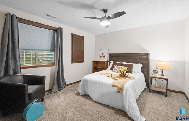 bedroom with baseboards, visible vents, ceiling fan, and light colored carpet