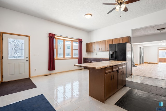 kitchen with visible vents, light countertops, ceiling fan, a textured ceiling, and baseboards