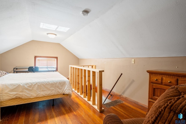 bedroom featuring light wood-style floors and lofted ceiling with skylight