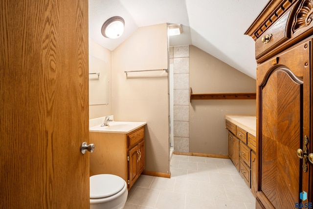 bathroom featuring baseboards, a shower, toilet, vaulted ceiling, and vanity