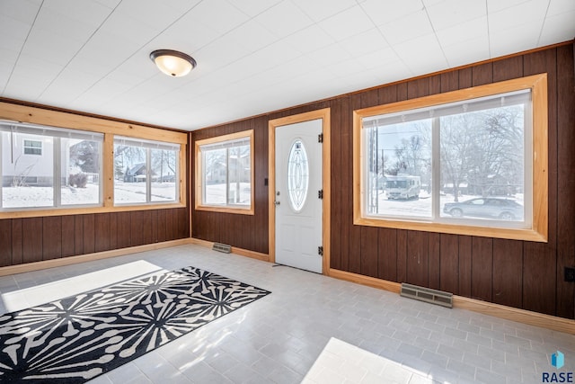 entrance foyer featuring wood walls, visible vents, and baseboards