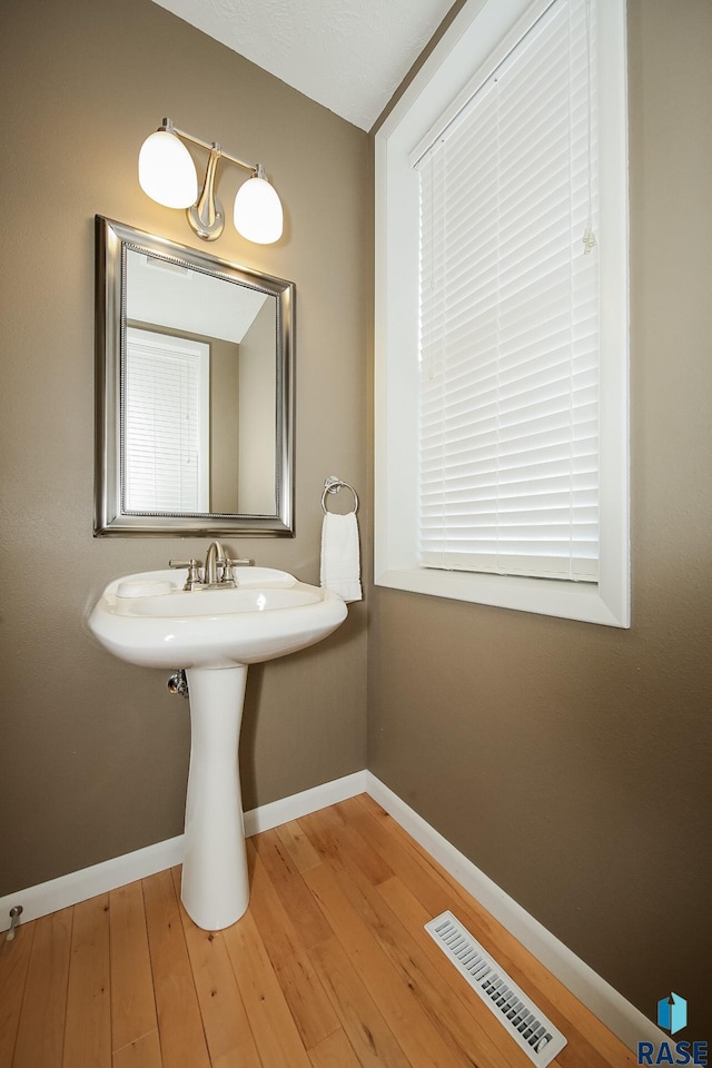 bathroom featuring baseboards, visible vents, and wood finished floors