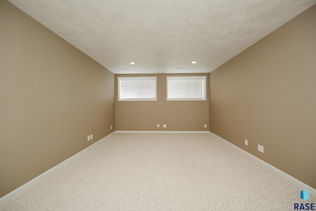 unfurnished room with light carpet, baseboards, a textured ceiling, and recessed lighting