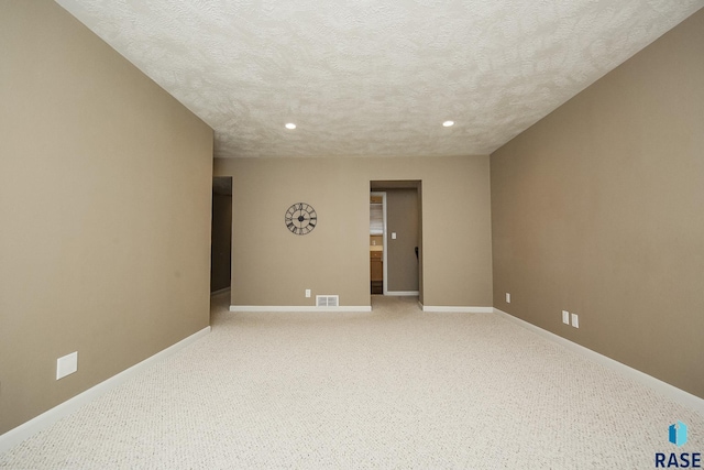 empty room featuring recessed lighting, visible vents, a textured ceiling, and baseboards