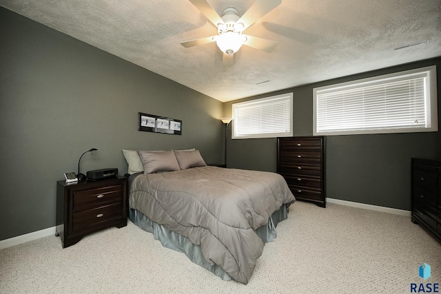 bedroom with visible vents, a textured ceiling, and baseboards