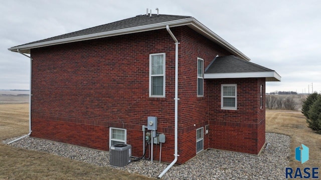 view of property exterior featuring central AC and brick siding