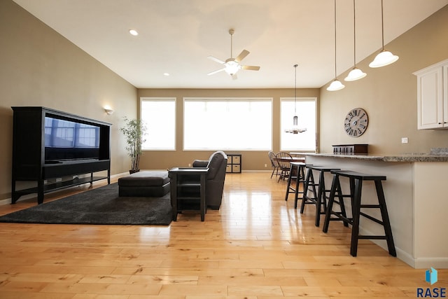 living area featuring ceiling fan, light wood finished floors, recessed lighting, and baseboards