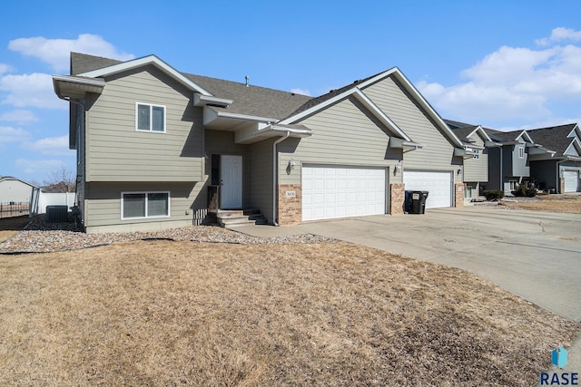 view of front of house with driveway, brick siding, central AC, and roof with shingles