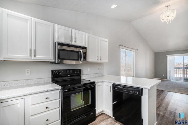 kitchen featuring a peninsula, white cabinetry, vaulted ceiling, open floor plan, and black appliances