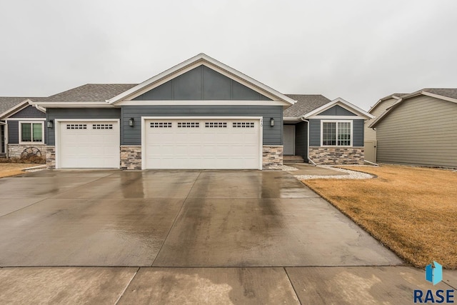 craftsman-style home featuring an attached garage, stone siding, driveway, and board and batten siding