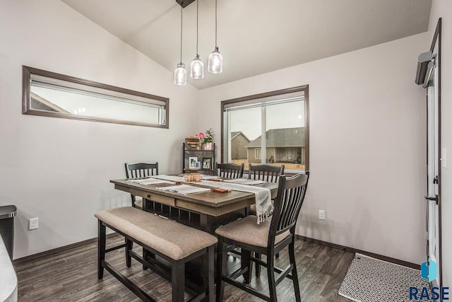 dining area featuring dark wood-style floors, vaulted ceiling, and baseboards