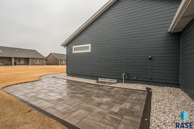 view of side of home with a patio area and a yard