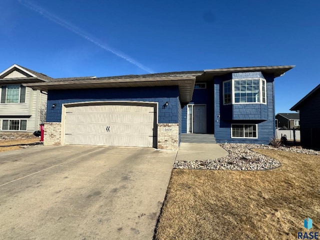 view of front of house with driveway, brick siding, and an attached garage