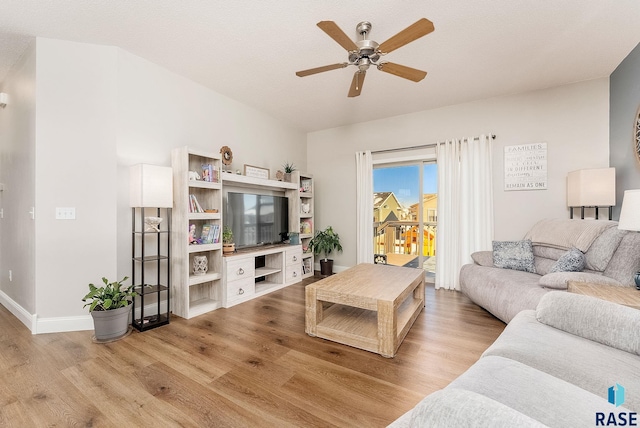 living room featuring baseboards, a ceiling fan, and wood finished floors