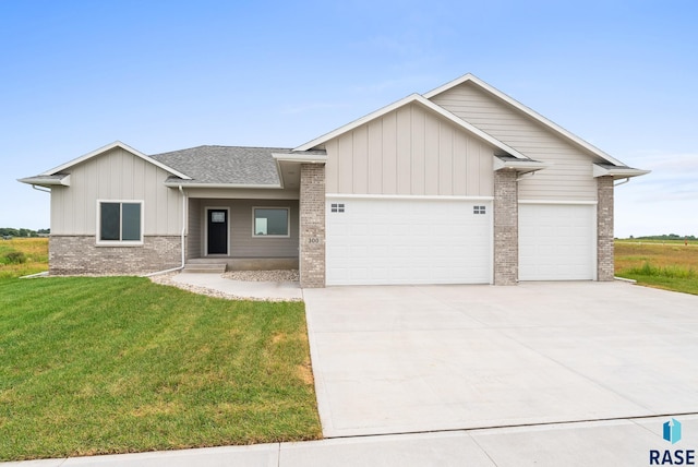 view of front of house with a garage, concrete driveway, brick siding, and a front lawn