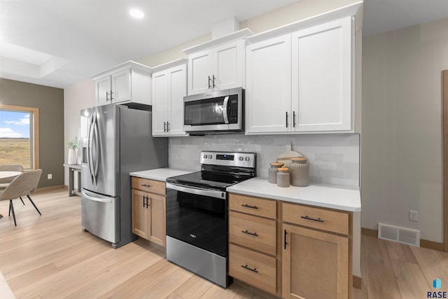 kitchen with visible vents, appliances with stainless steel finishes, light countertops, and backsplash