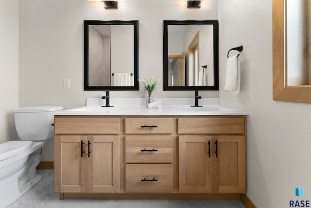 bathroom featuring a sink, toilet, and double vanity