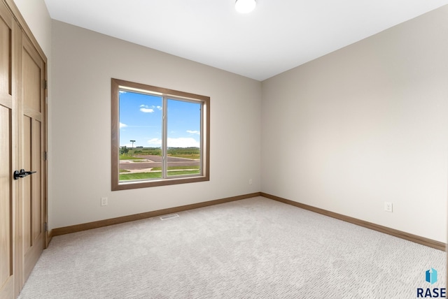 unfurnished bedroom with light colored carpet, visible vents, and baseboards