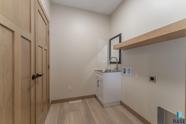 laundry area with hookup for a washing machine, cabinet space, light wood-style floors, hookup for an electric dryer, and a sink