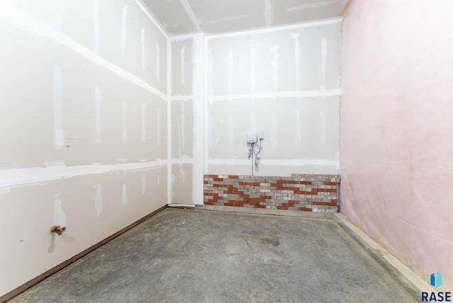 unfurnished room with unfinished concrete flooring