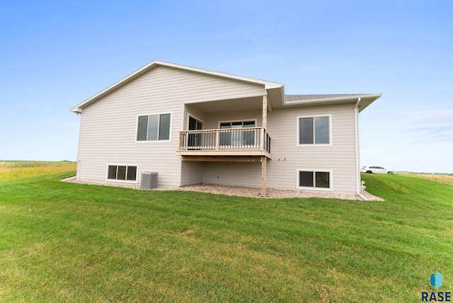 rear view of property featuring central AC unit and a lawn