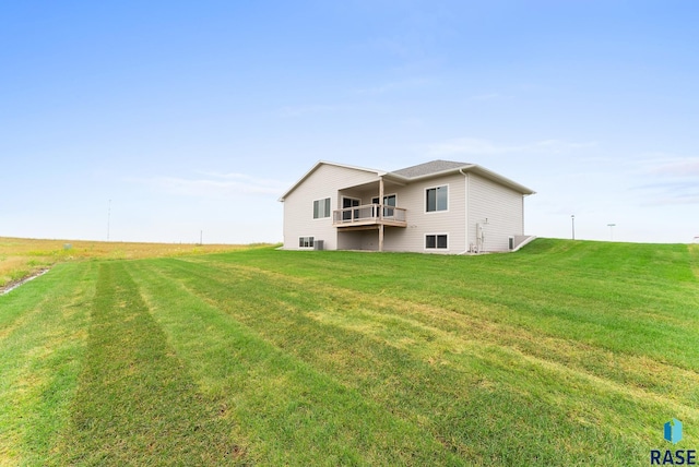 rear view of house with a yard and a balcony