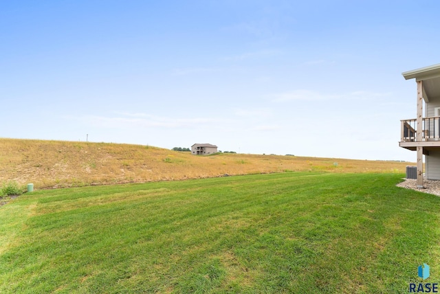 view of yard with central air condition unit and a rural view