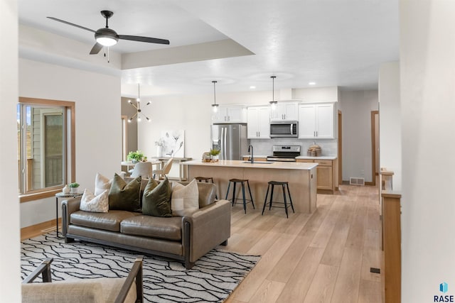 living area featuring light wood finished floors, visible vents, baseboards, ceiling fan, and recessed lighting