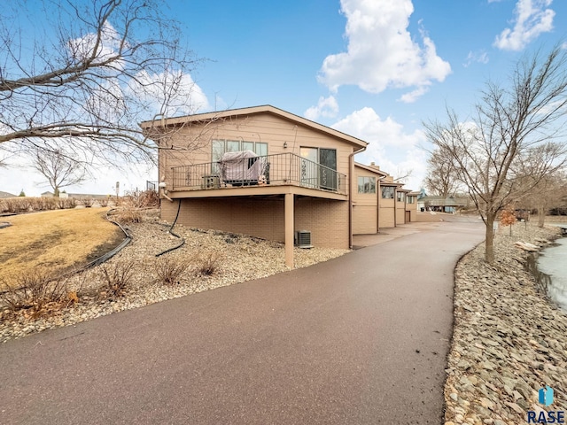 view of side of property with central AC and a balcony