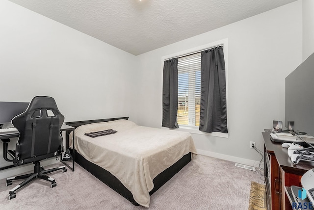 bedroom with a textured ceiling, carpet floors, visible vents, and baseboards