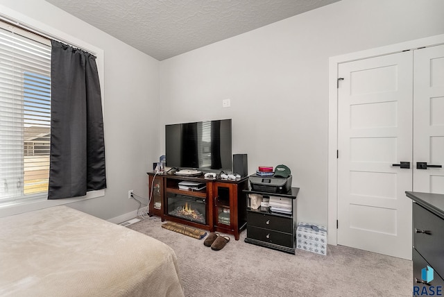 bedroom featuring carpet, a textured ceiling, and baseboards