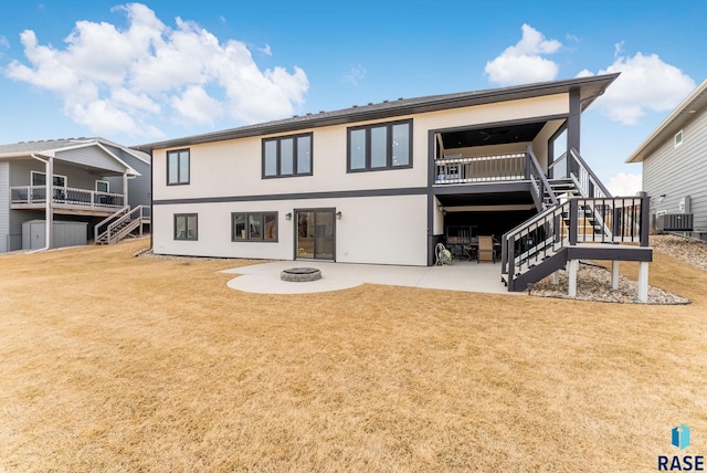 back of house featuring a fire pit, stairway, a patio, and a yard