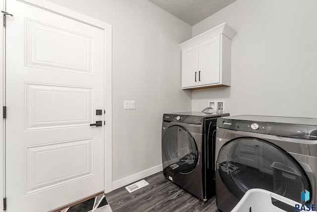 laundry room with cabinet space, baseboards, separate washer and dryer, and dark wood-type flooring