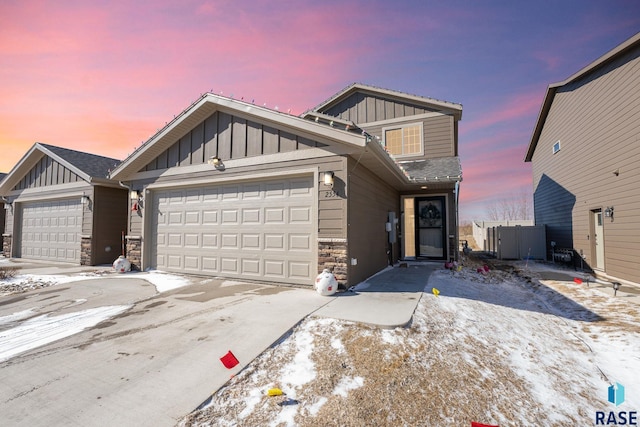 view of front facade featuring a garage, stone siding, and board and batten siding