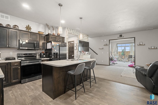 kitchen with visible vents, stainless steel appliances, light countertops, and open floor plan