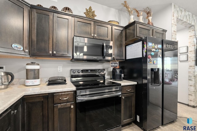 kitchen featuring light countertops, appliances with stainless steel finishes, light wood-type flooring, and dark brown cabinetry