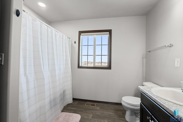 full bath featuring baseboards, visible vents, toilet, wood finished floors, and vanity