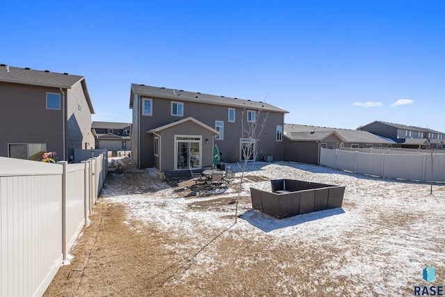 back of property with entry steps, a patio area, a fenced backyard, and a residential view