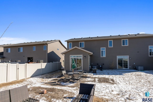 rear view of property featuring fence, central AC unit, and a patio