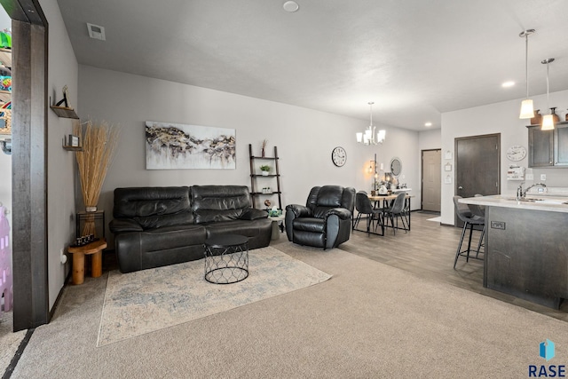 living area featuring light carpet, recessed lighting, visible vents, and a notable chandelier