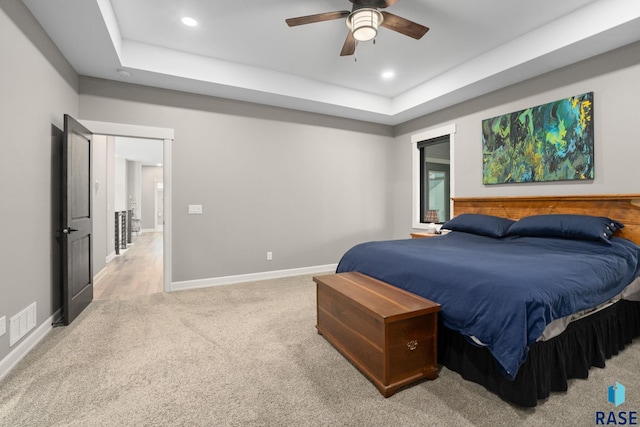 bedroom featuring baseboards, visible vents, light colored carpet, a tray ceiling, and recessed lighting