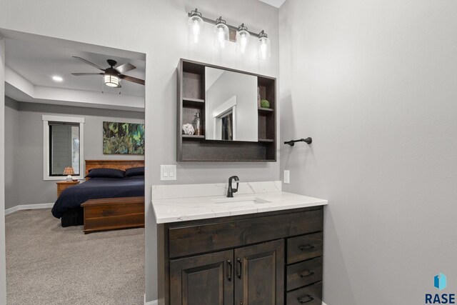 bathroom with ceiling fan, vanity, and baseboards