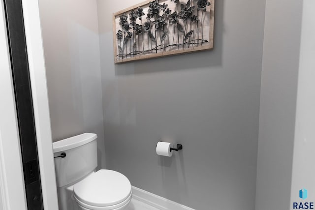 bathroom with toilet and baseboards